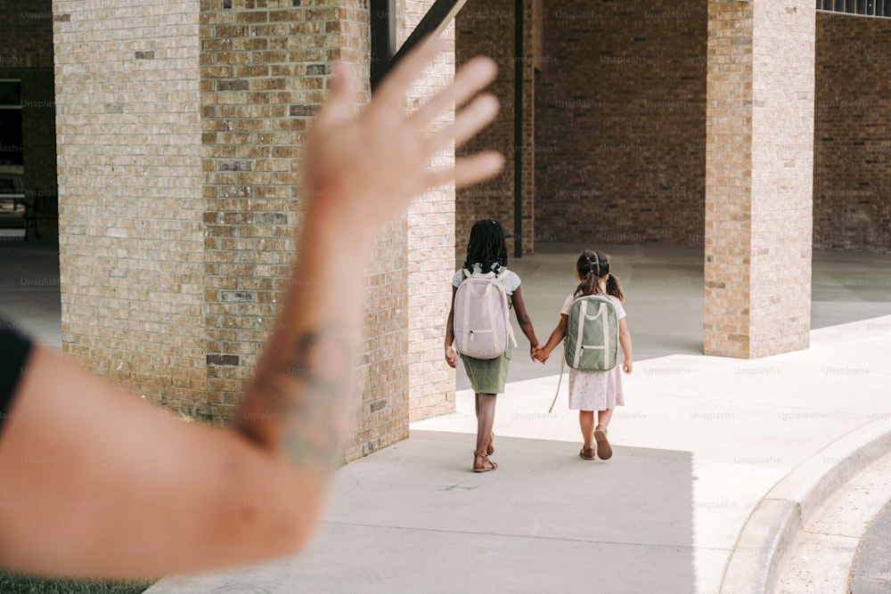 a woman holding the hand of a young girl