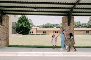 a woman and two children are walking under a shelter