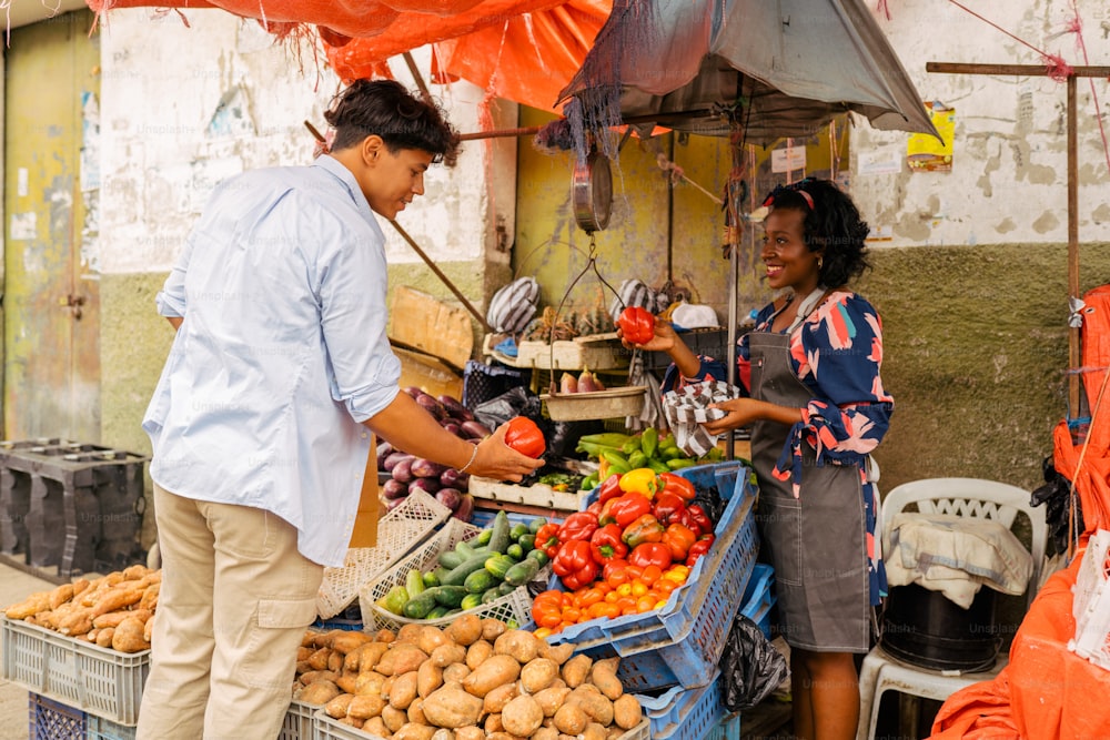 a man and woman standing in front of a fruit stand