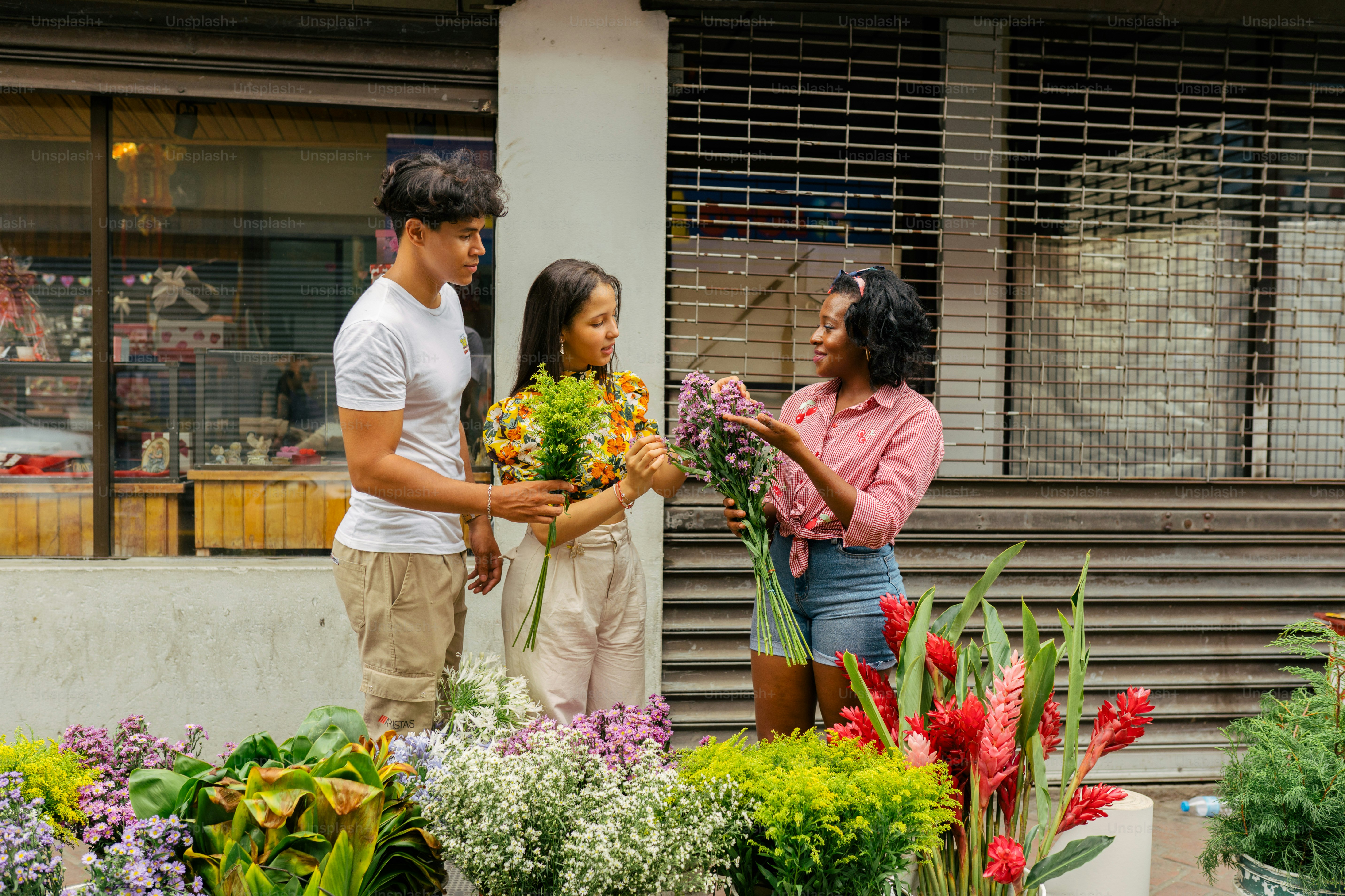 a group of people standing around a bunch of flowers