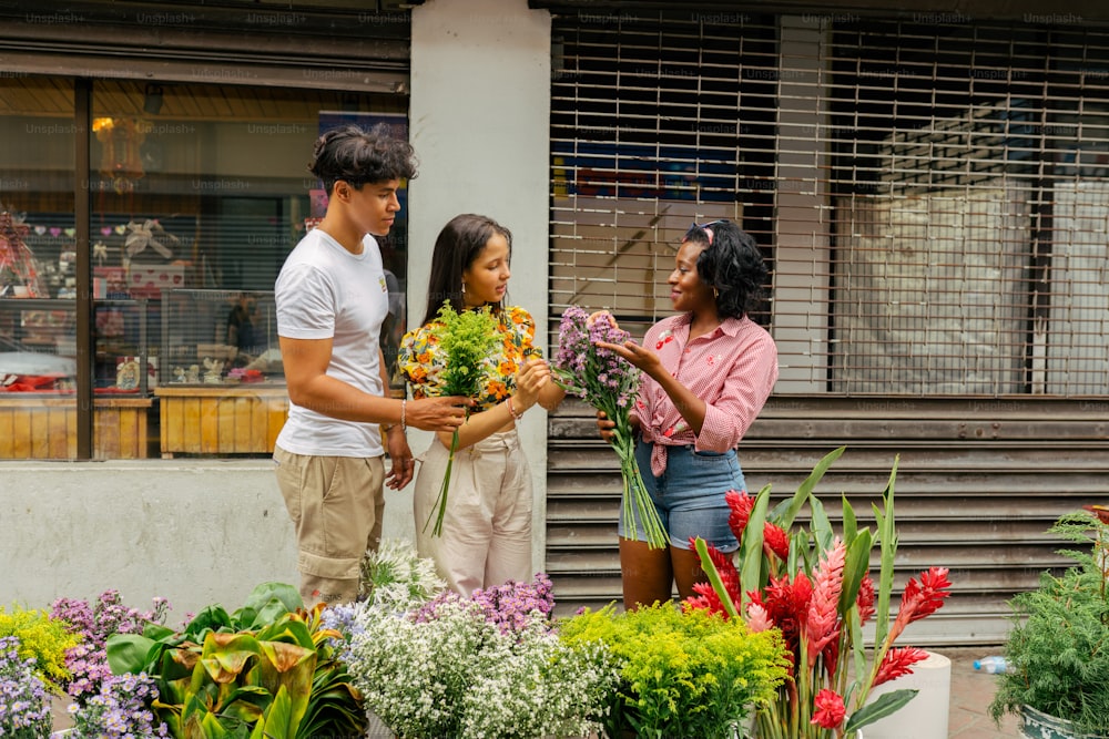 a group of people standing around a bunch of flowers