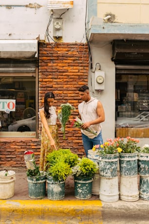 a man and a woman standing in front of a flower shop