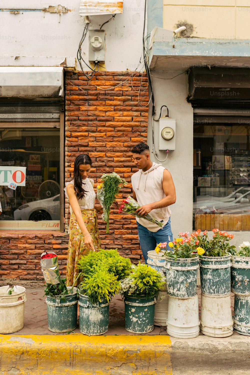 a man and a woman standing in front of a flower shop