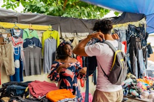 a man and a woman looking at clothing on display