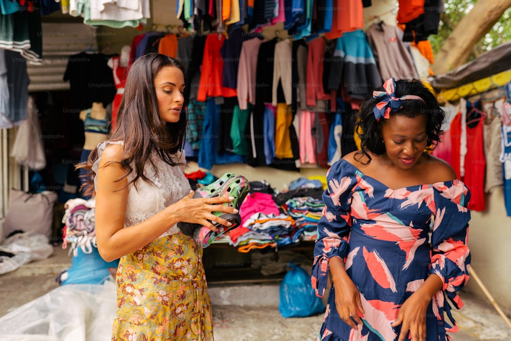 duas mulheres em frente a uma loja de roupas