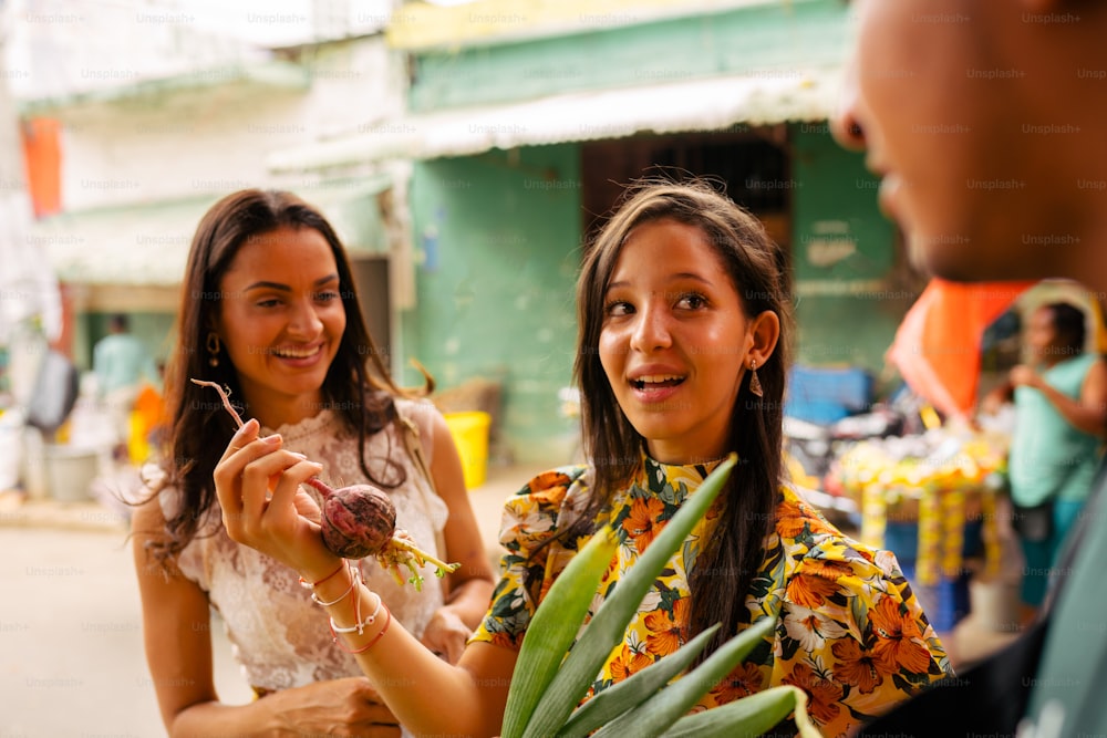 a woman holding a piece of fruit next to a man