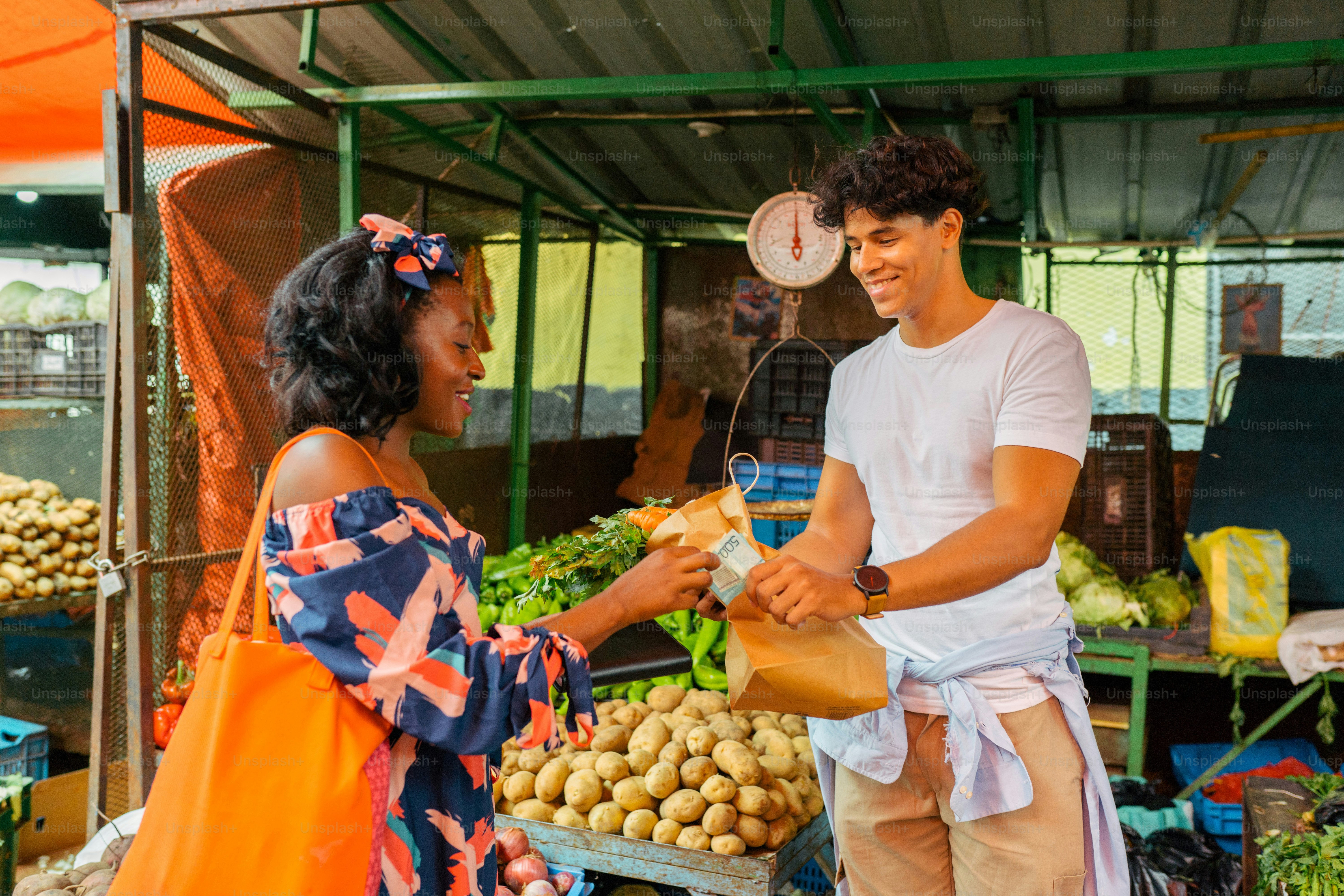 a man and a woman standing in front of a produce stand
