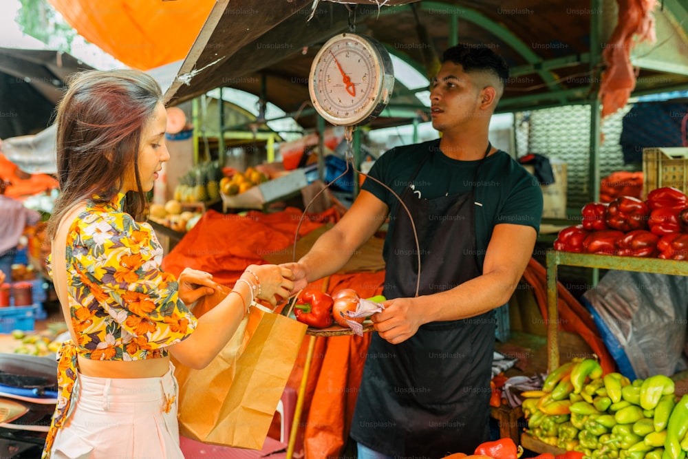 a man and a woman standing in front of a fruit stand
