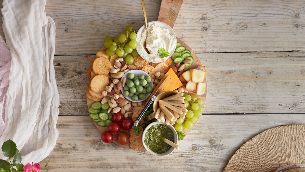 a platter of cheese, crackers, grapes and nuts