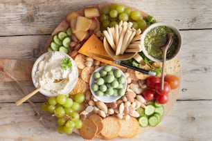 a platter of cheese, crackers, grapes, crackers, grapes,