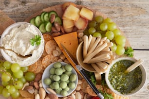 a platter of cheese, crackers, grapes, nuts, and crackers