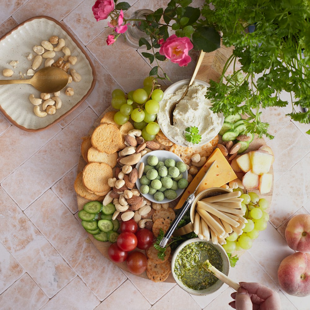 a platter of cheese, crackers, fruit and vegetables