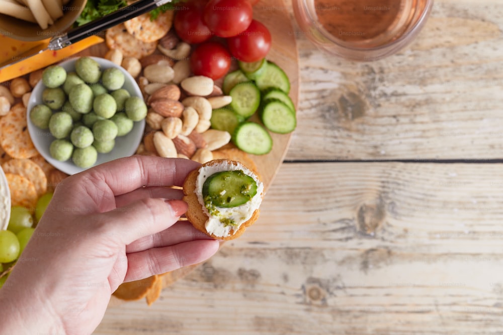 a person is holding a sandwich in front of a platter of food