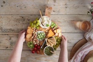 a person holding a platter of food on a wooden table