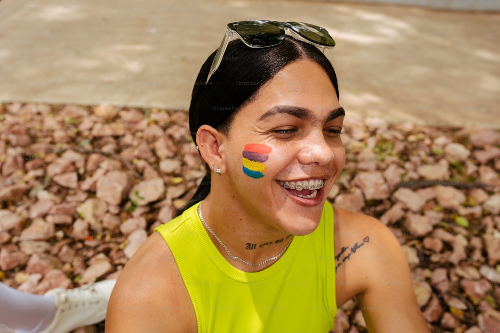 uma mulher com um arco-íris pintado no rosto