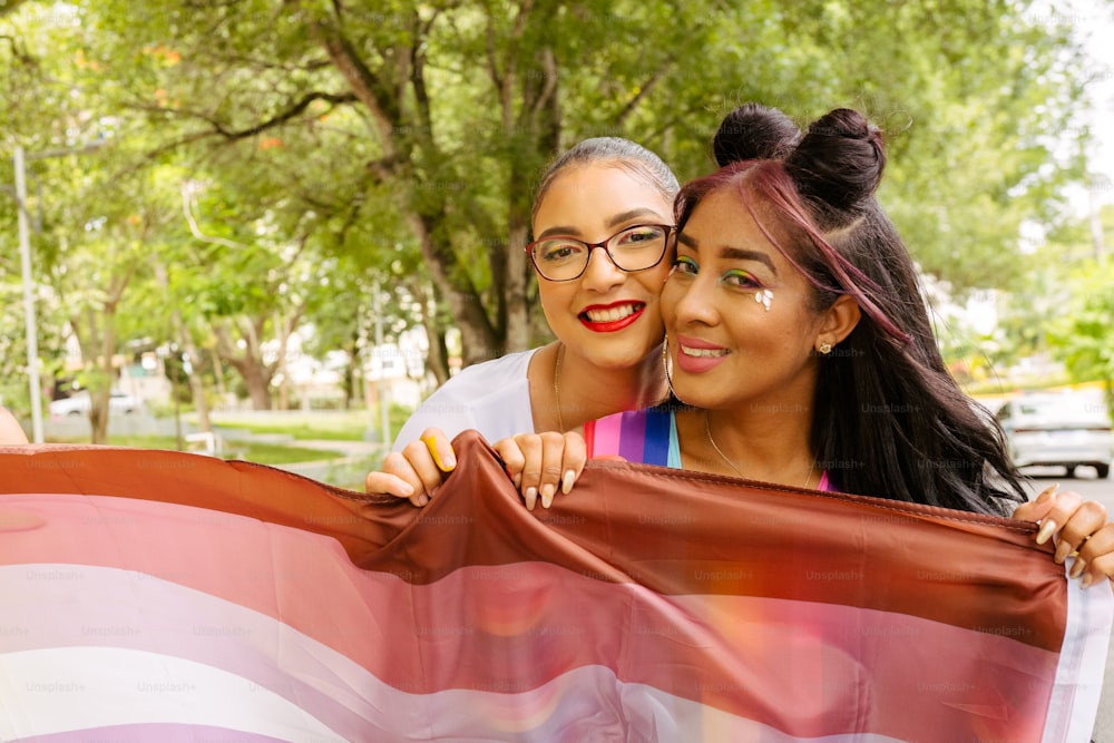 Duas mulheres seguram uma grande bandeira americana