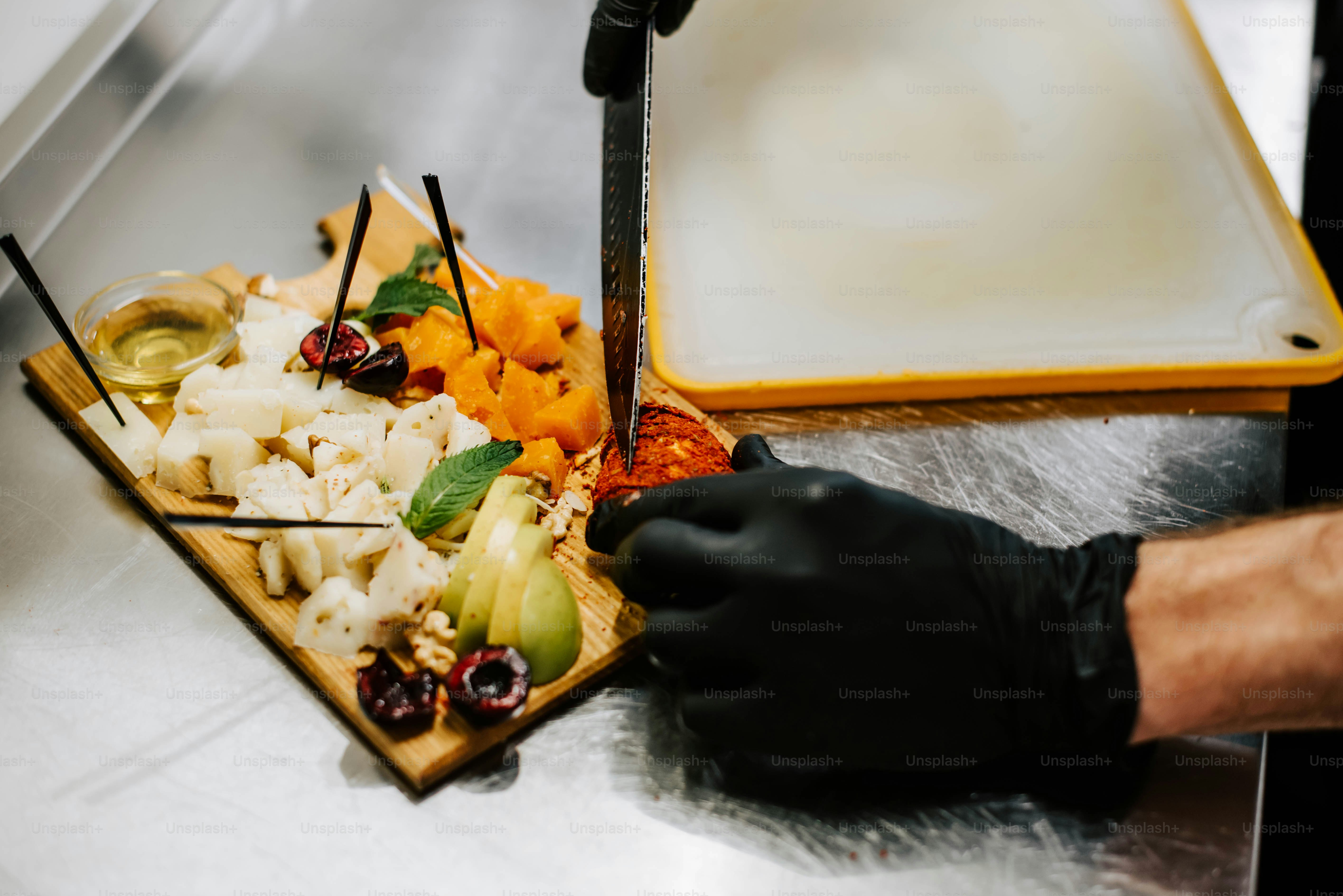 a person in black gloves preparing a platter of food
