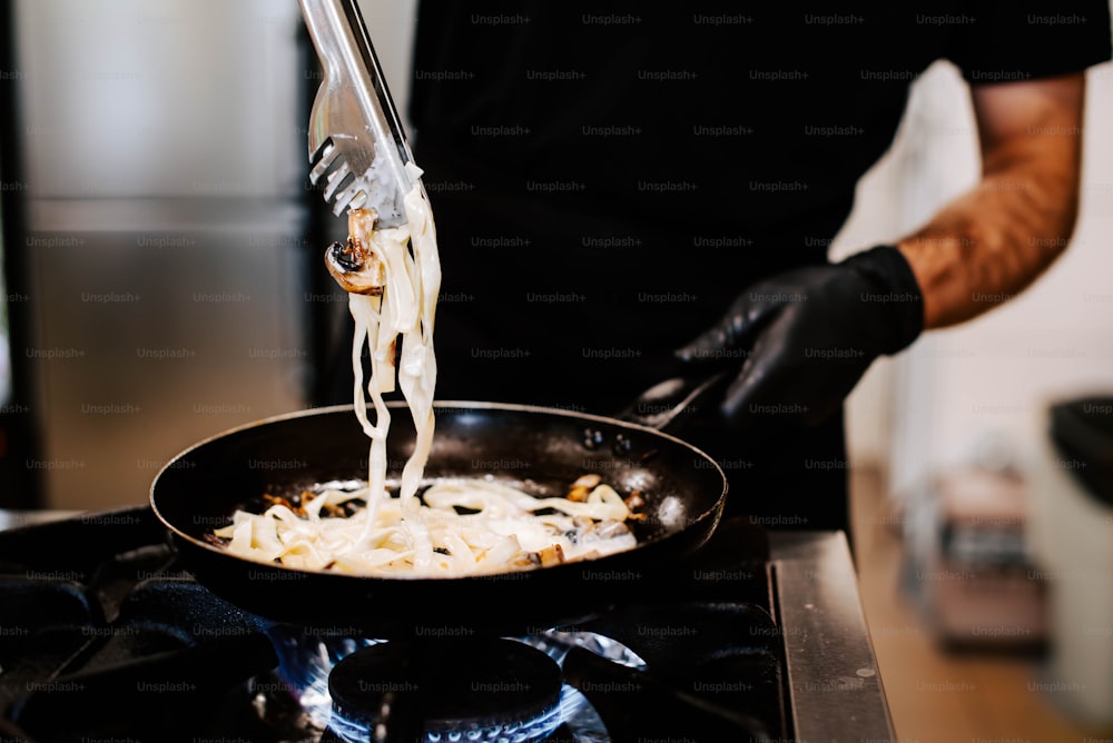 a man is cooking pasta in a pan on the stove