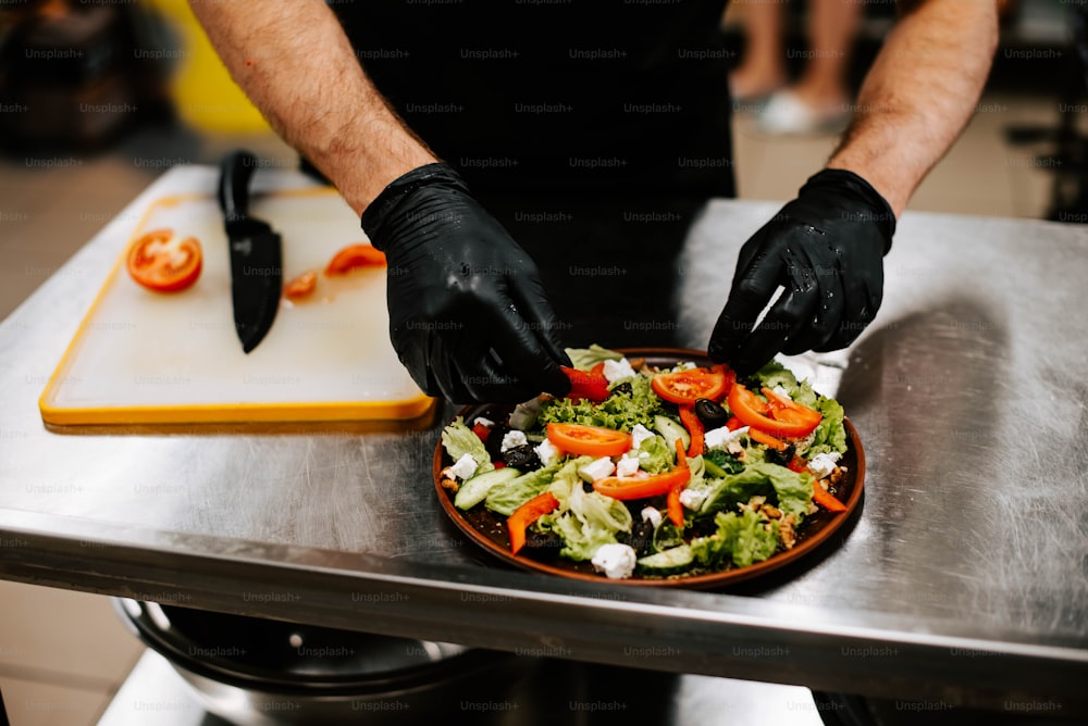 a person in black gloves and black gloves preparing a salad