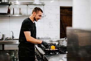 Un homme dans une cuisine préparant de la nourriture sur un poêle