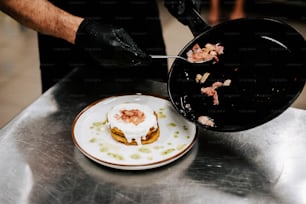 a person in black gloves and a plate with food on it