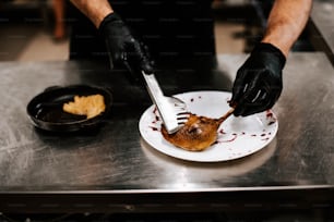 a person in black gloves is eating food on a plate