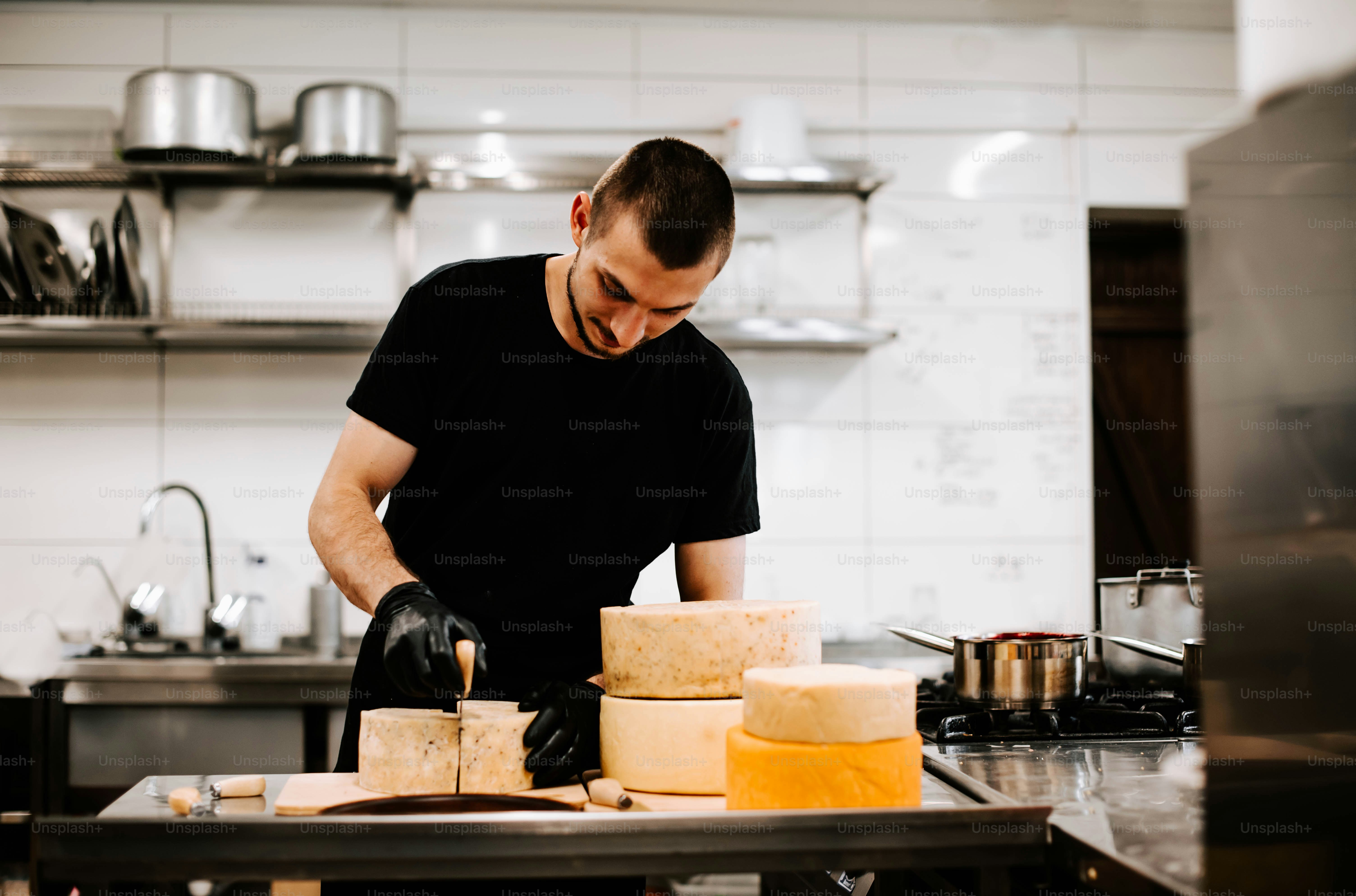 a man in a black shirt is making cheese