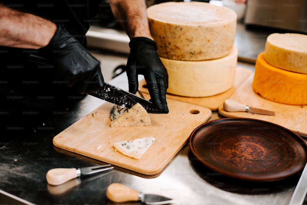 uma pessoa cortando queijo em uma tábua de corte