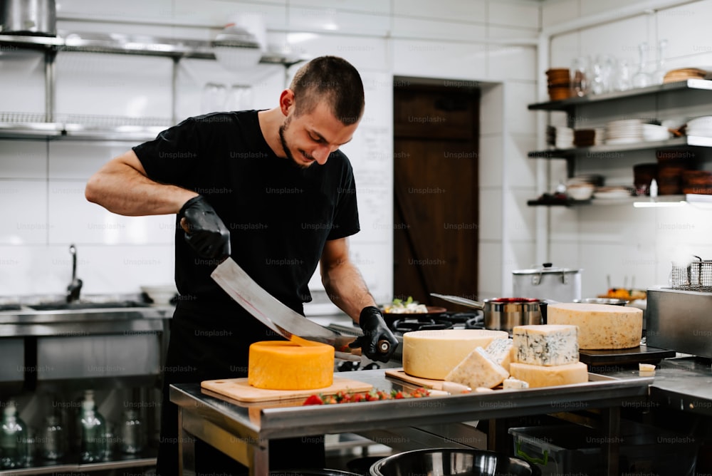 Un homme dans une cuisine tranchant du fromage sur une planche à découper
