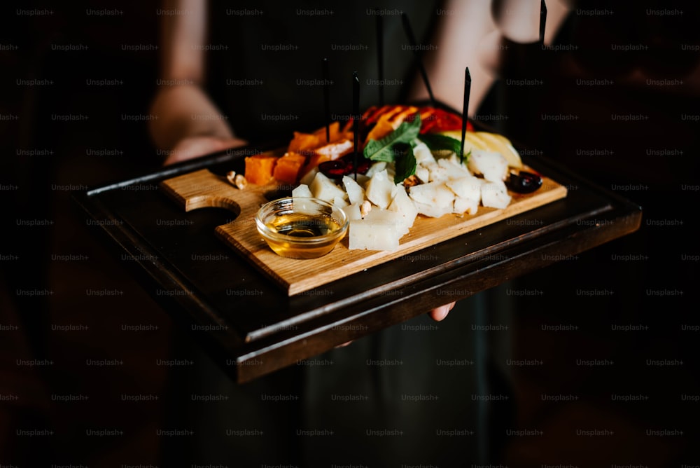 a person holding a tray with a variety of food on it