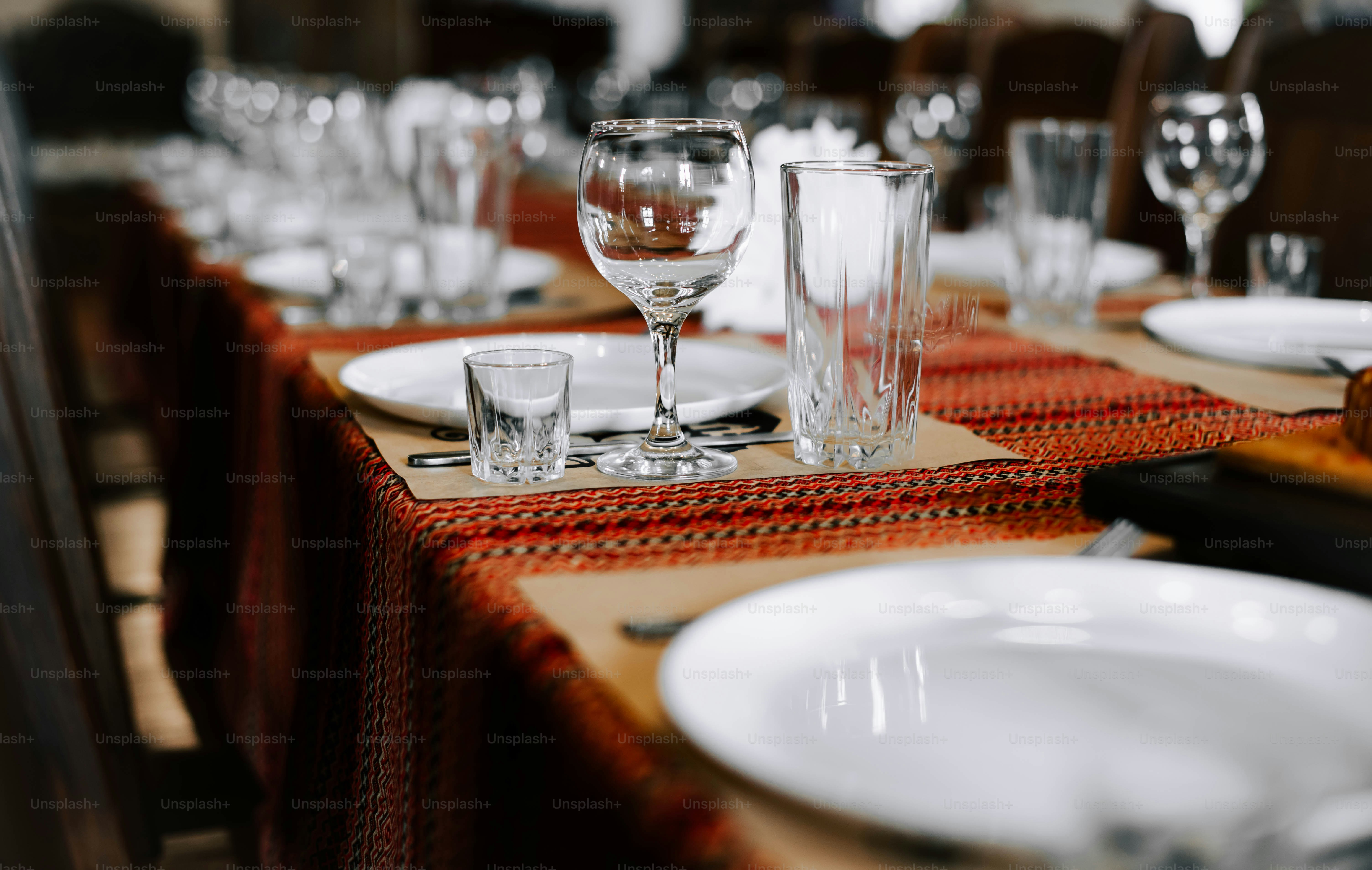 a table set with glasses, plates and utensils