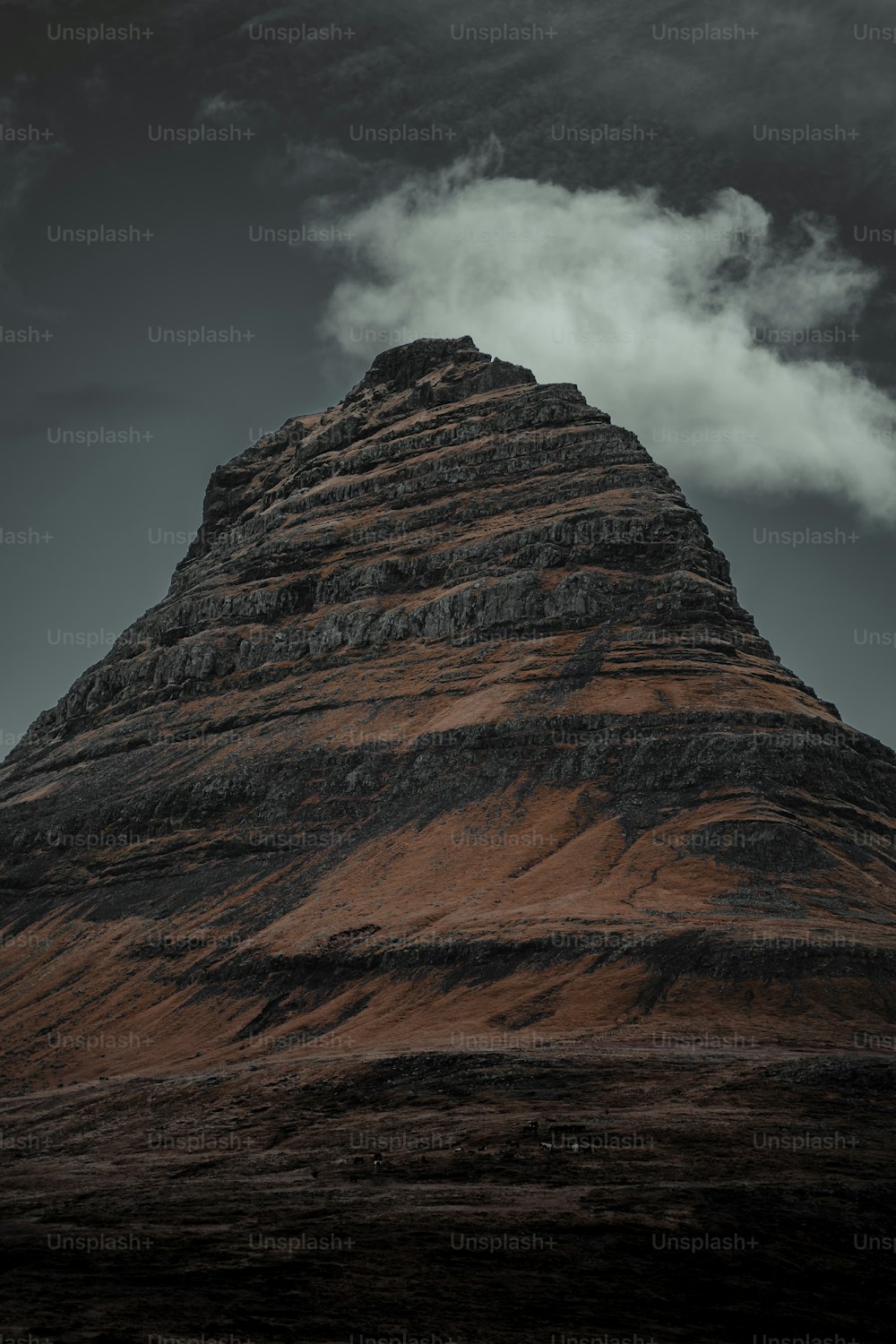 a very tall mountain with some clouds in the sky