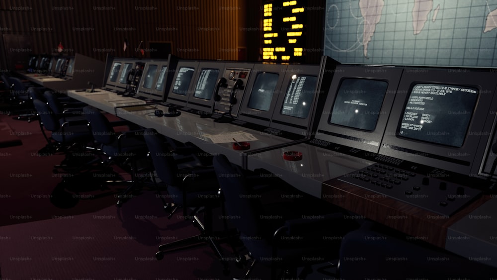 a row of computer monitors sitting on top of a desk