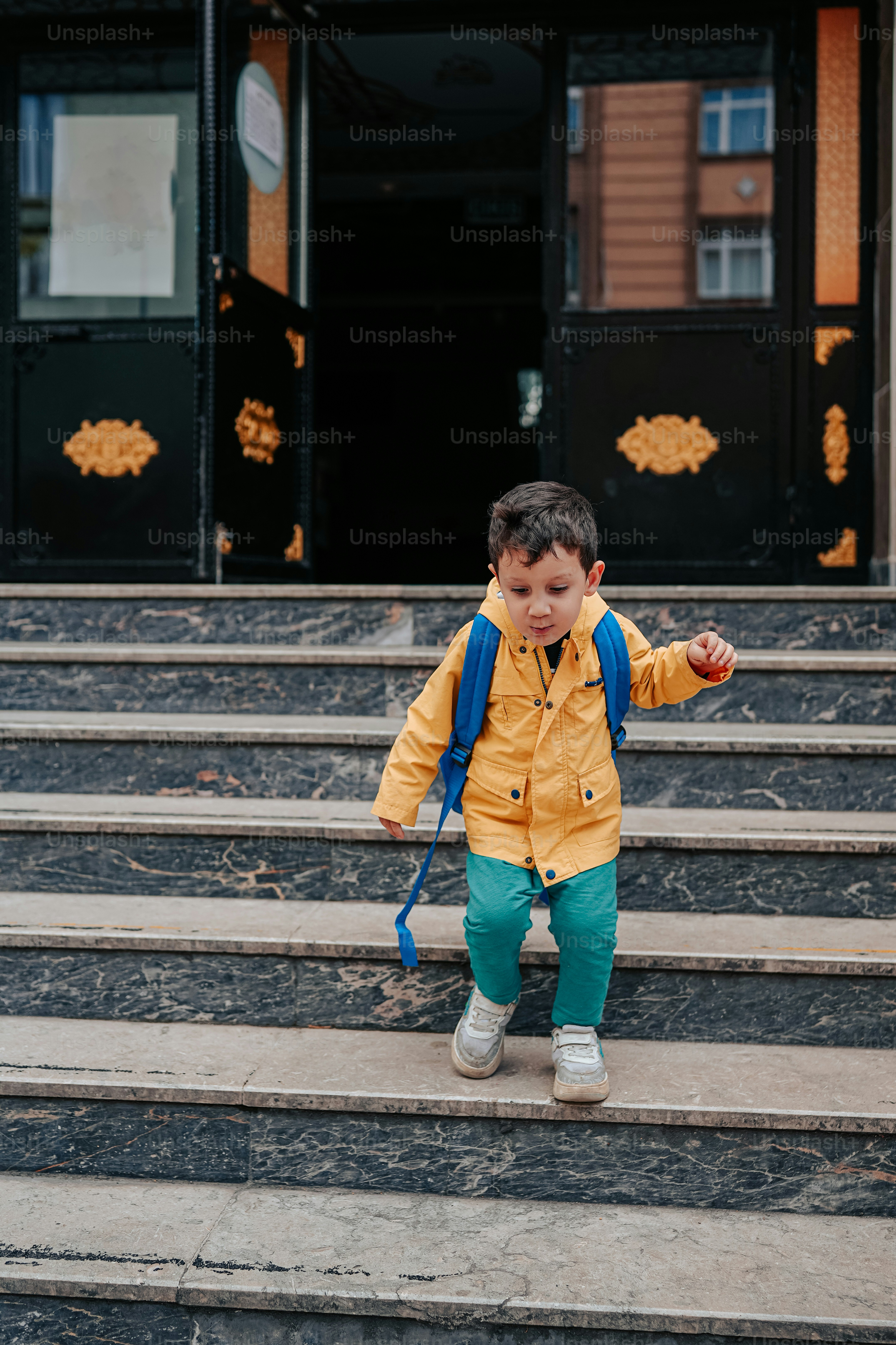 a little boy that is standing on some steps
