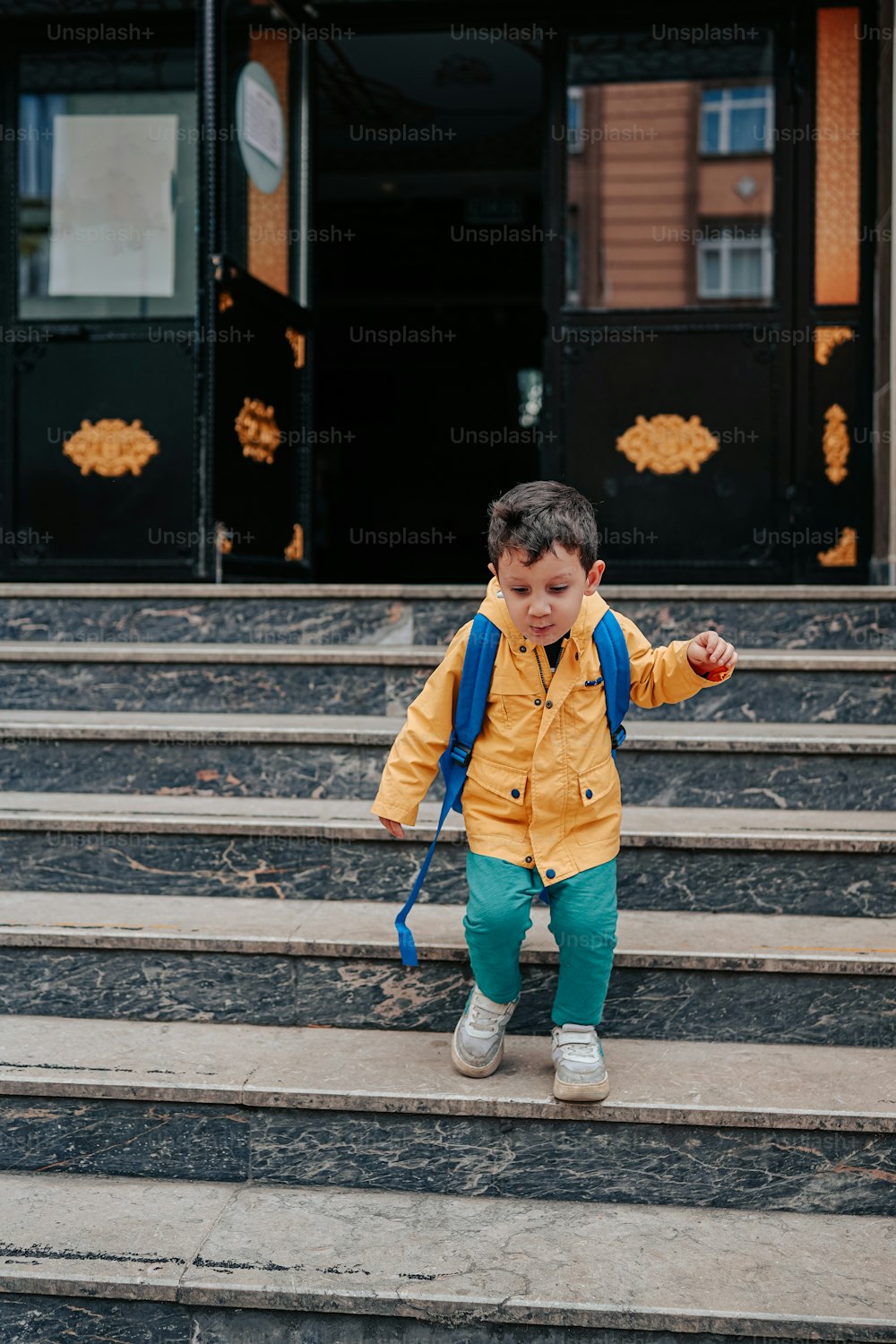 a little boy that is standing on some steps