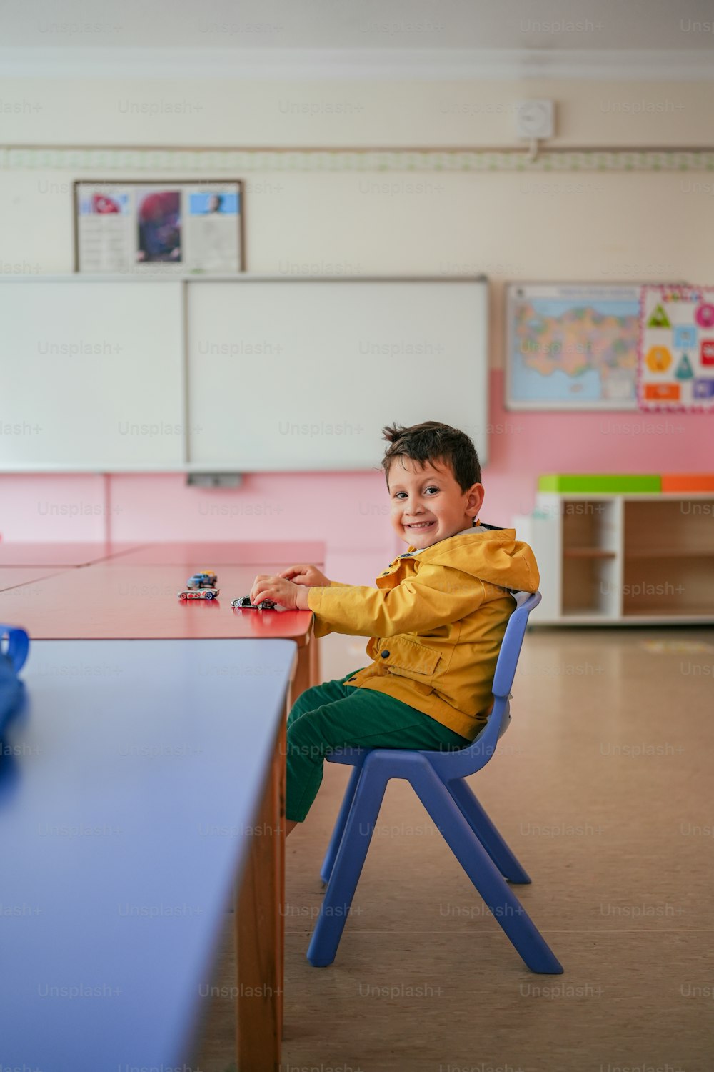 a young boy sitting at a table in a classroom