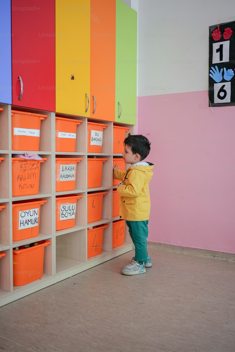 a little boy standing in front of a colorful wall