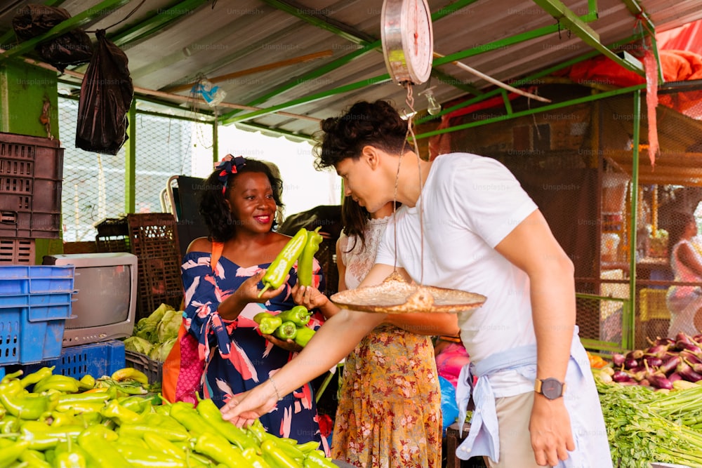um homem e uma mulher fazendo compras em um mercado ao ar livre