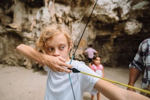 Un niño sosteniendo un arco y una flecha