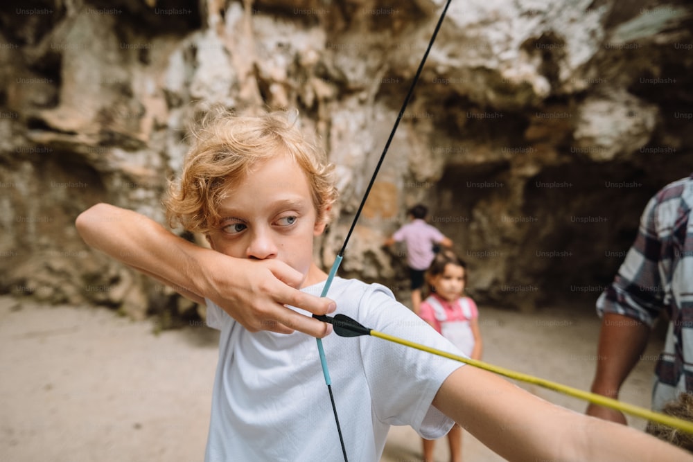 a young boy holding a bow and arrow