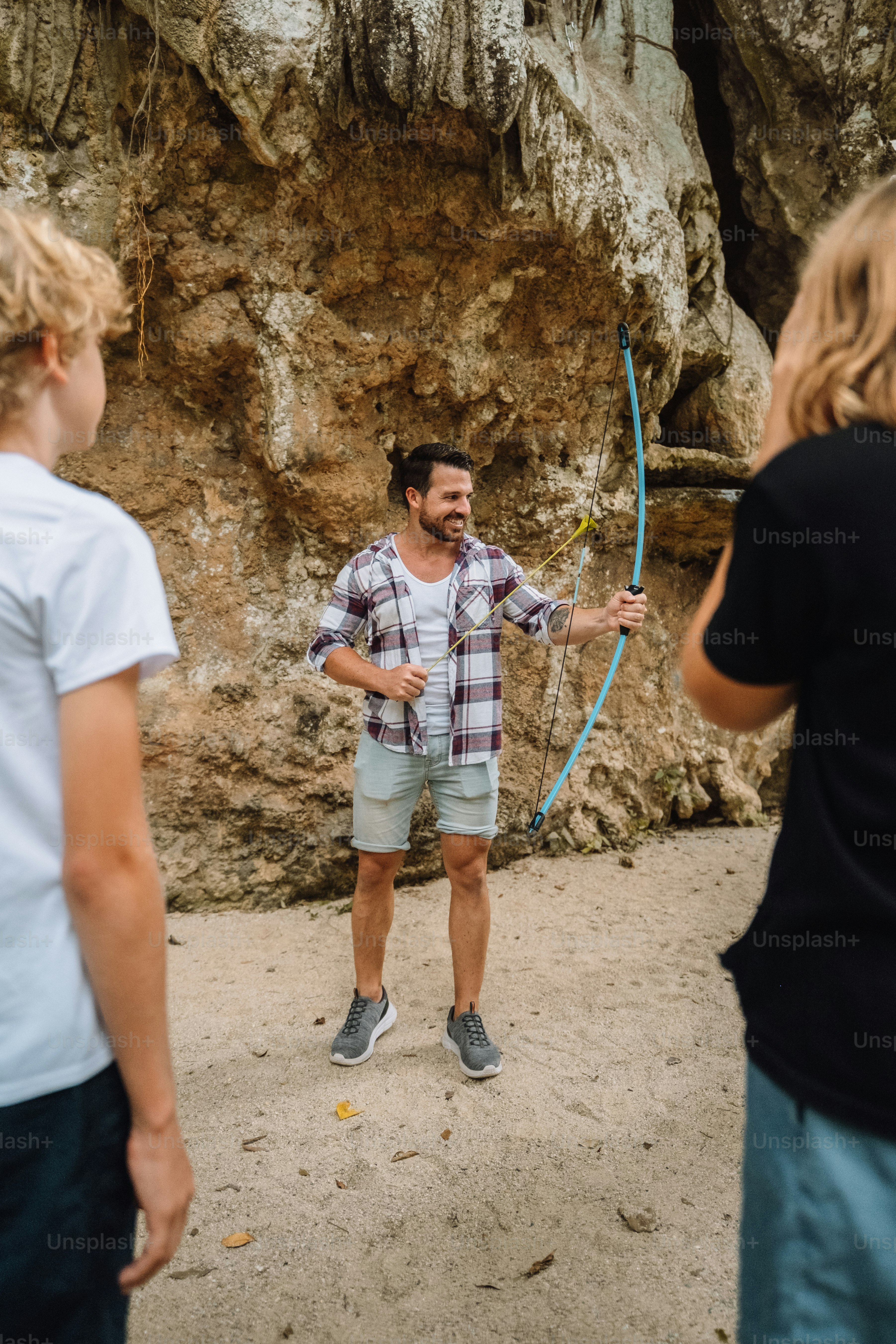 A group of people standing in front of a cave photo – Summer Image on ...
