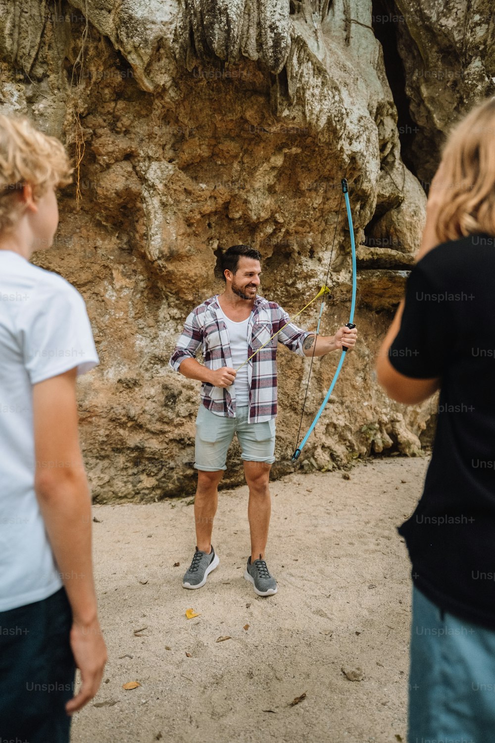 a man holding a bow and arrow while standing next to a woman