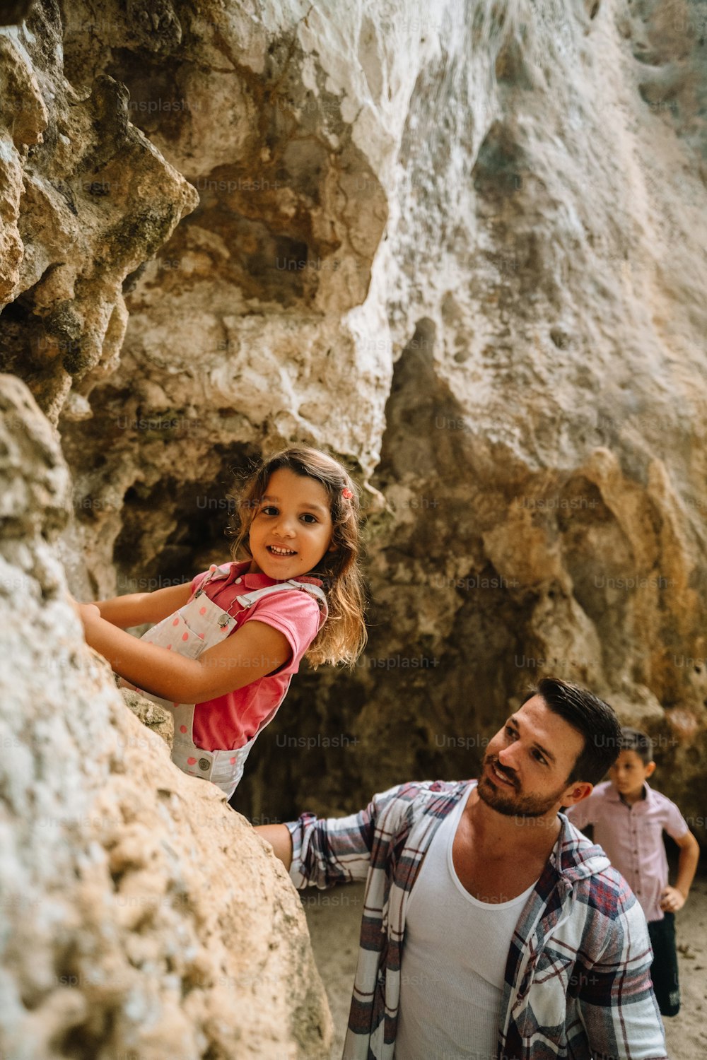 Un uomo e una bambina che si arrampicano su una montagna