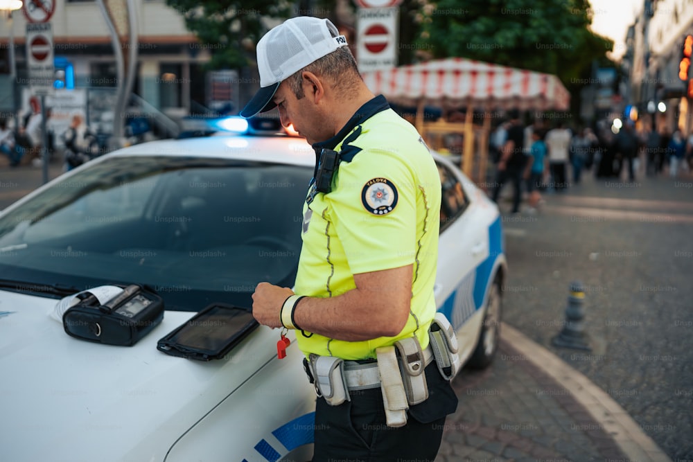 Un agente di polizia in piedi accanto a un'auto della polizia
