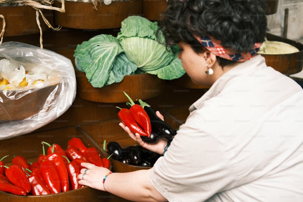 a woman holding a bunch of red peppers