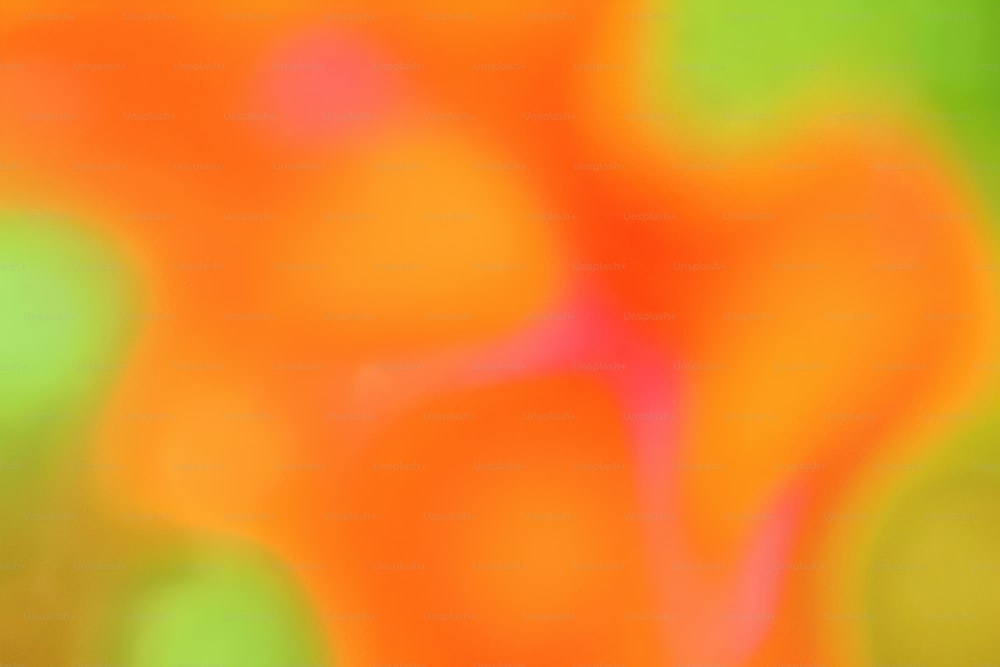 ein verschwommenes Bild eines orangefarbenen und grünen Hintergrunds