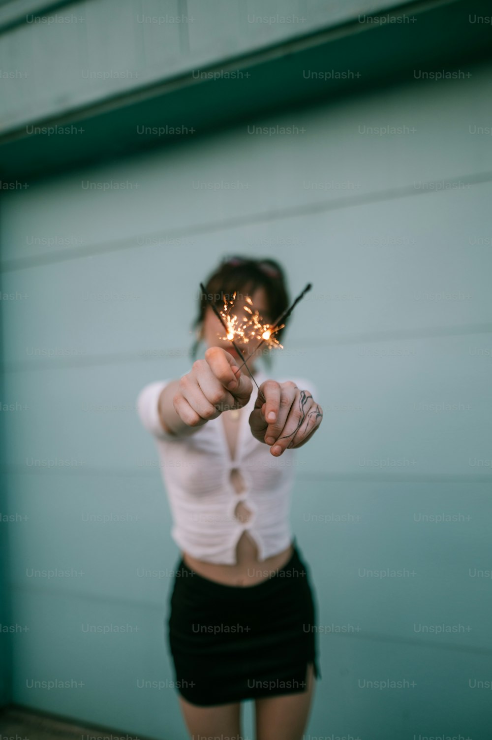 a woman holding a sparkler in her right hand