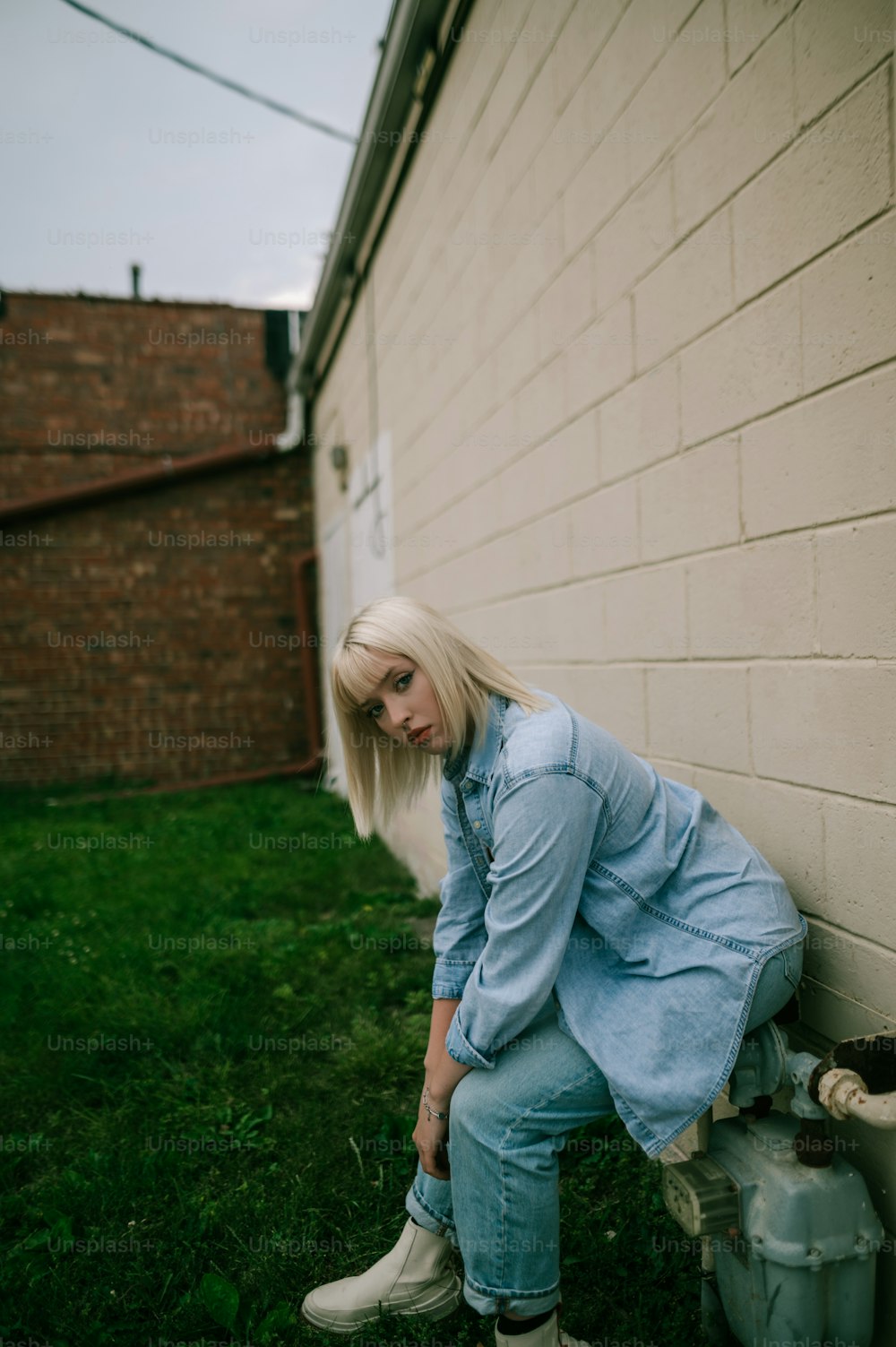 a woman leaning against a wall next to a fire hydrant