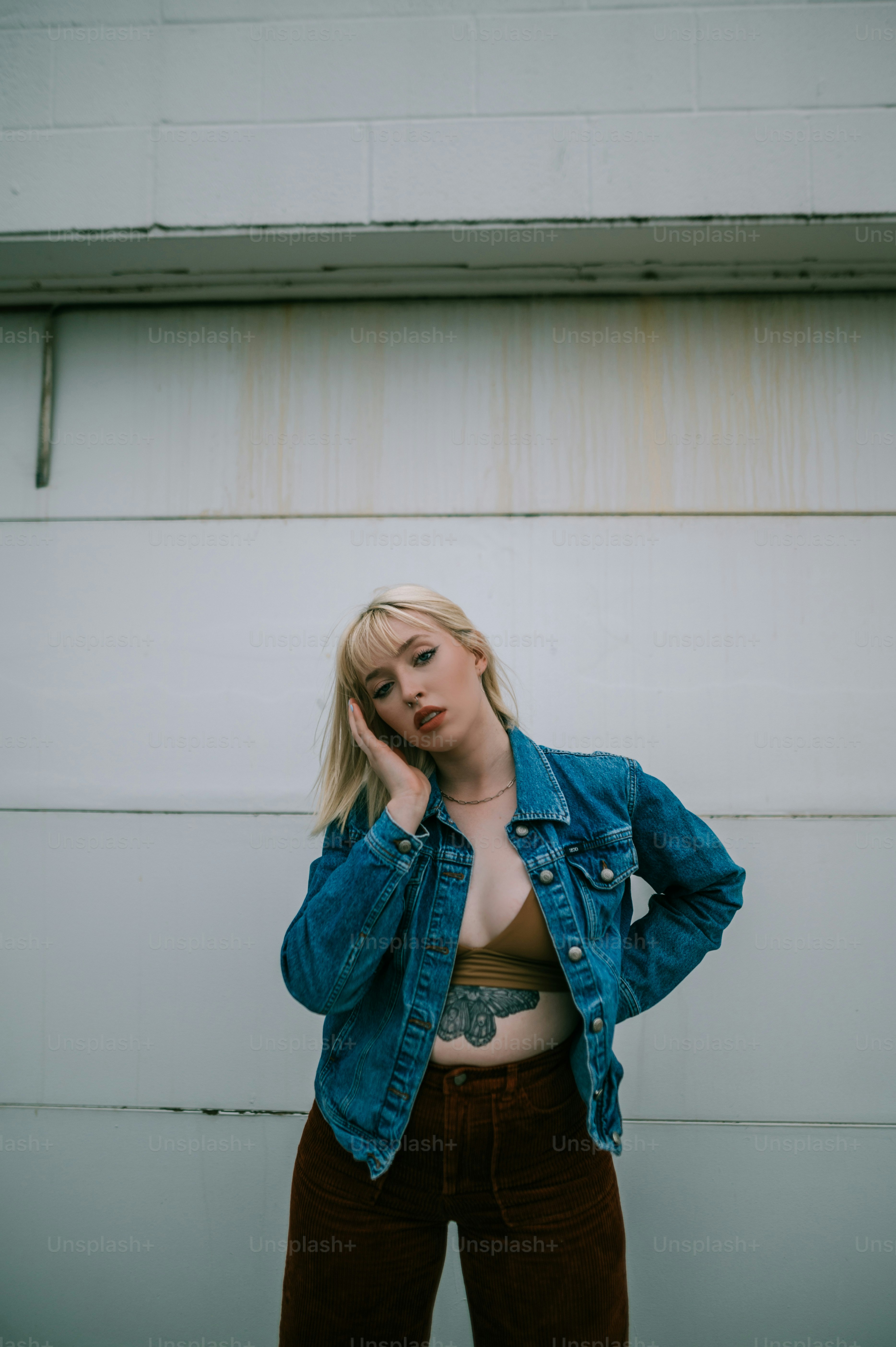 Une femme vêtue d’une veste en jean et d’un pantalon marron