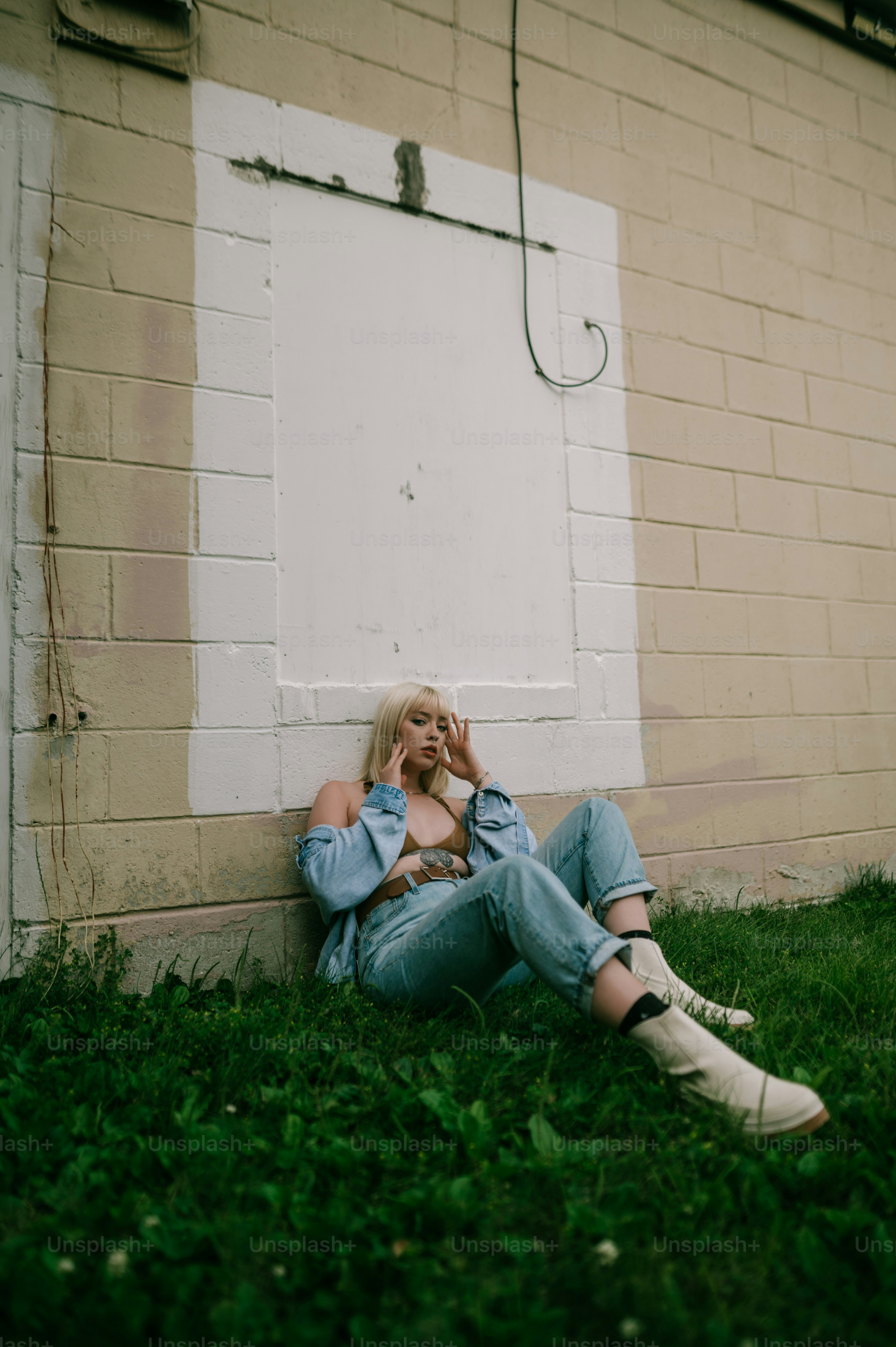 Une femme assise sur l’herbe parlant au téléphone portable